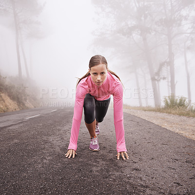 Buy stock photo Shot of a young female runner about to start a training session on a misty morning