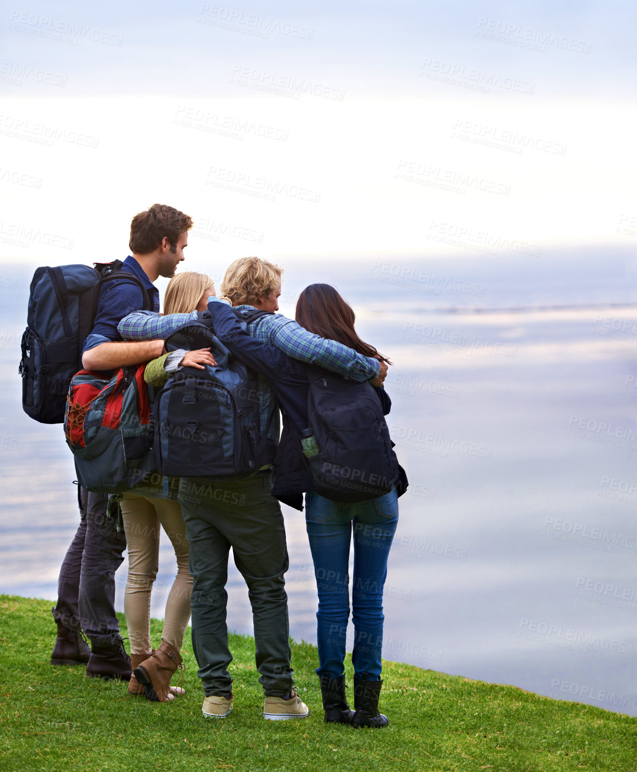 Buy stock photo Friends, people hug with back and hiking on mountain, travel with view of horizon outdoor, ocean and backpacking in Europe. Support, trust and friendship, trekking for adventure and looking at nature