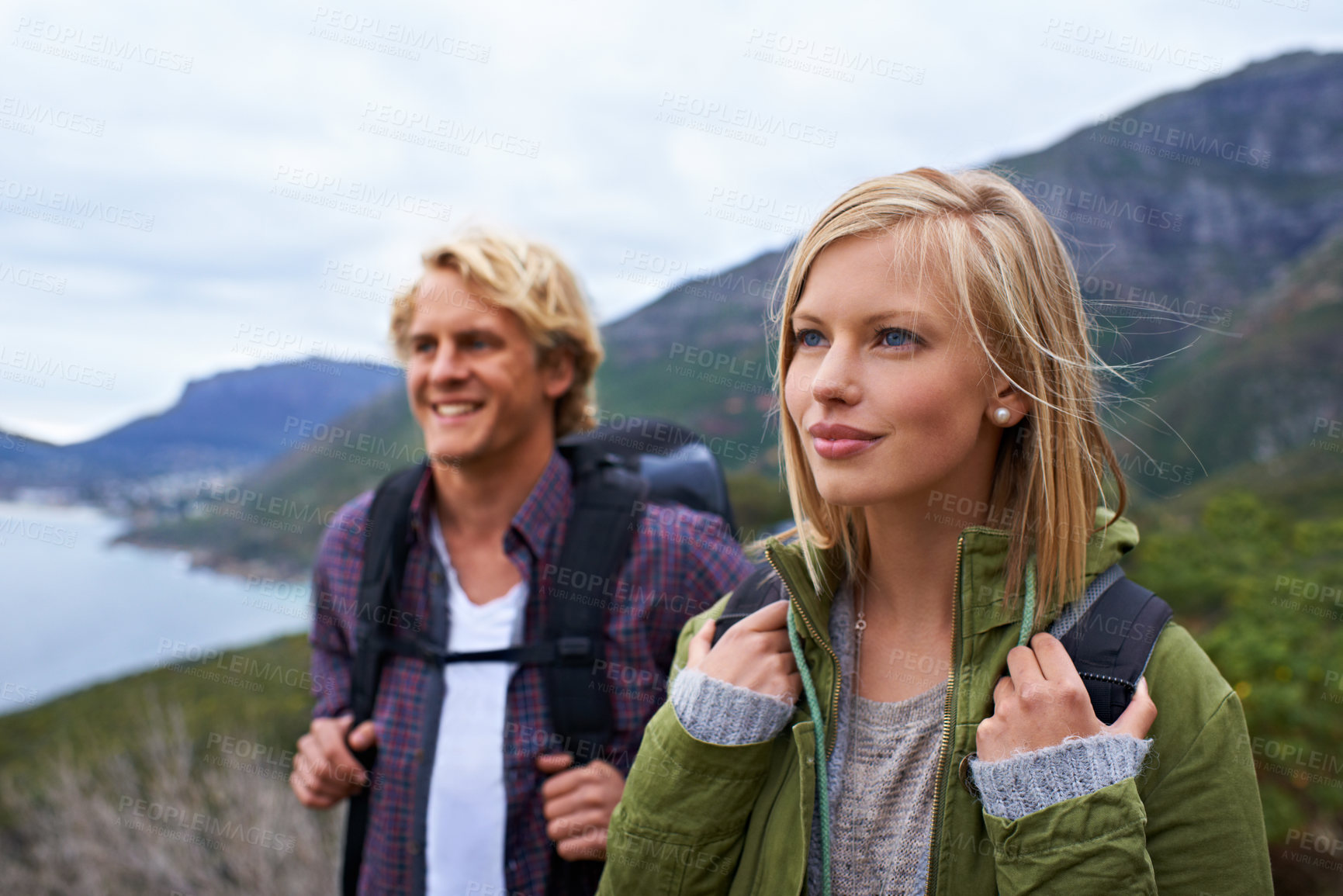 Buy stock photo Happy couple, hiking and backpack on mountain for sightseeing, travel or outdoor journey in nature. Face of young man, woman or hikers carrying bag on back for trekking, fitness or adventure in woods