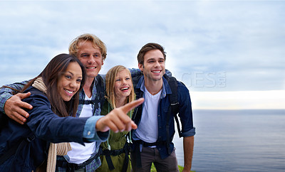 Buy stock photo Friends, group and happy on mountain top for hiking, adventure and pointing to location, travel and sightseeing. Happy young people with backpack and excited to explore, trekking or outdoor journey 