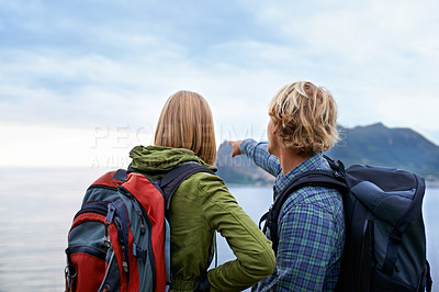 Buy stock photo Hiking, nature and couple on mountain pointing with backpack for freedom, trekking or explore landscape. Travel, dating and man and woman hug by scenic view on holiday, vacation and outdoor adventure