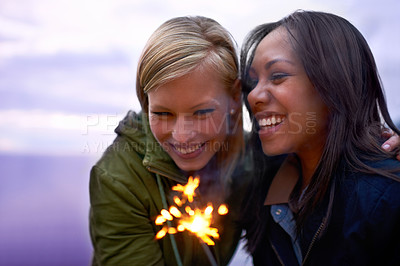 Buy stock photo Women, friends and happy with sparklers outdoor, celebration and fun with hiking or travel in nature. Friendship, bonding and sparks with horizon, smile for adventure together and evening sky