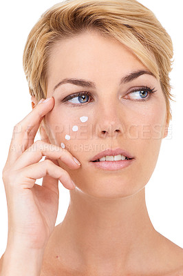 Buy stock photo Cropped shot of a gorgeous young woman isolated on white and applying some moisturizer to her face