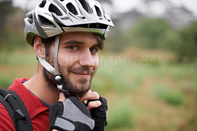 Buy stock photo A young cyclist fastening his helmet
