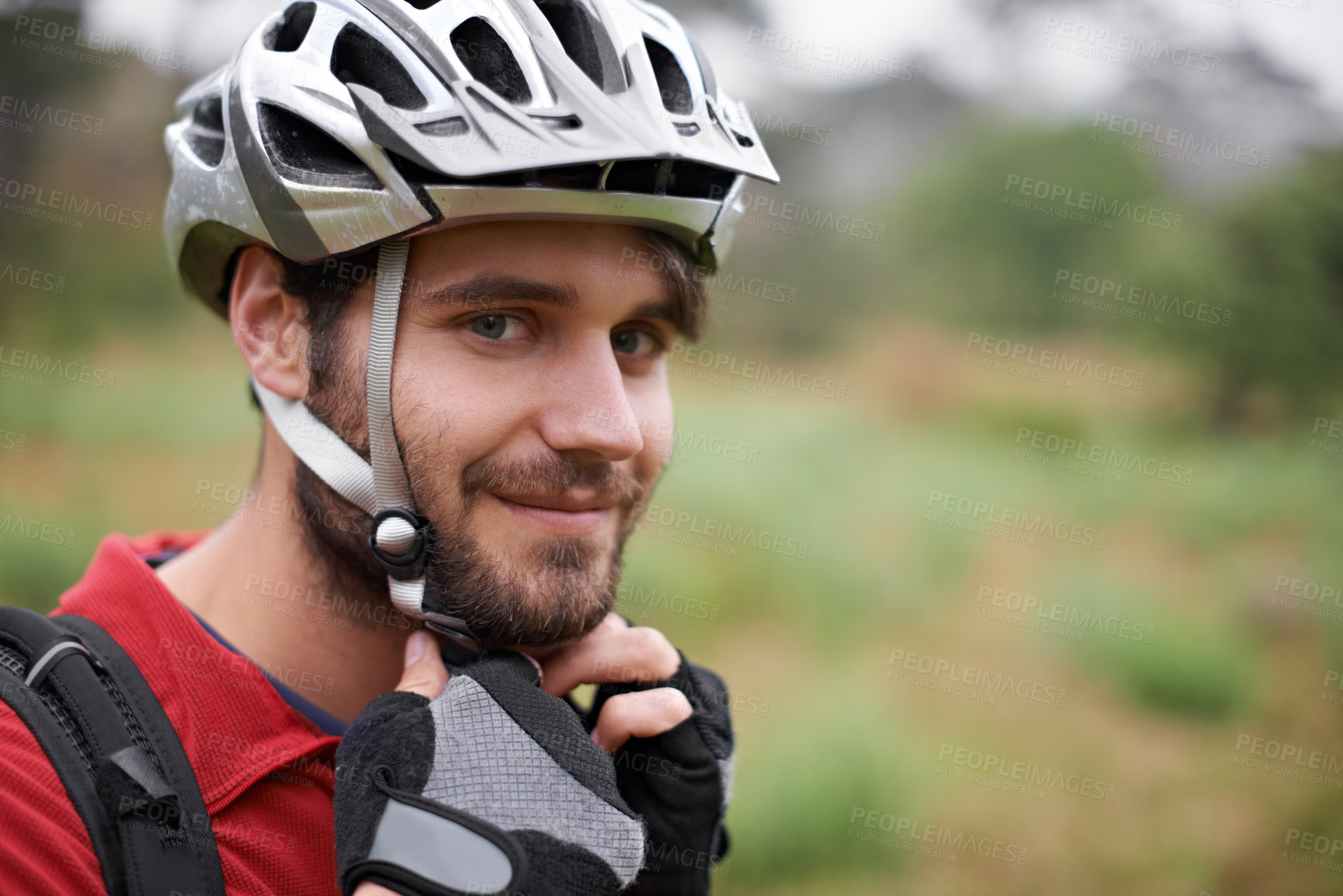Buy stock photo A young cyclist fastening his helmet