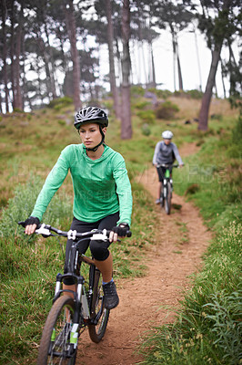 Buy stock photo Woman, bike and cycling outdoor on trail for exercise, workout or adventure in forest with fitness. People, cyclists and bicycle with helmet in woods or off road for sport, hobby and travel in nature