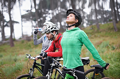 Buy stock photo Cycling, sports and race of friends in nature getting ready for triathlon, training or adventure on mountains or forest. Group of people on bicycle stretching, drinking water or start in competition