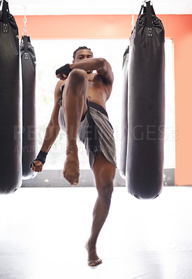 Buy stock photo Man, kick boxing and bag with training, knee and combat for exercise with balance, power and precision in gym. African athlete, person or fighter with workout, fitness or strike for challenge in dojo