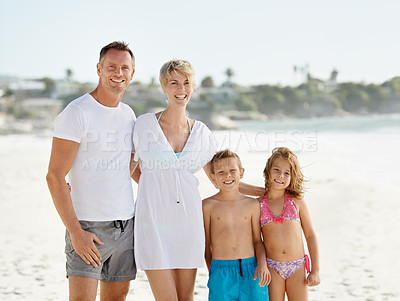 Buy stock photo A happy young family standing on the beach while on vacation