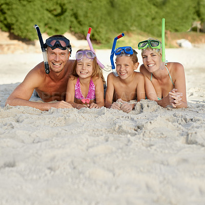 Buy stock photo A family in snorkeling gear lying on the sand at the beach