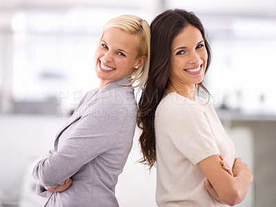 Buy stock photo Cropped portrait of two businesswomen standing back-to-back in the office