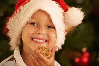 Buy stock photo Christmas, young child with cookie and smile in portrait, holiday and celebration in family home. Happy kid, chocolate cookies and festive in Santa hat and youth with happiness in childhood and xmas.