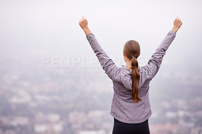 Buy stock photo Rearview shot of a woman training outdoors with her arms outstretched