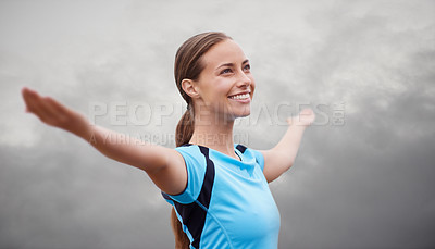 Buy stock photo Shot of a young woman training outdoors with her arms outstretched