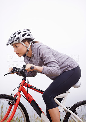 Buy stock photo Shot of a female mountain biker out for an early morning ride