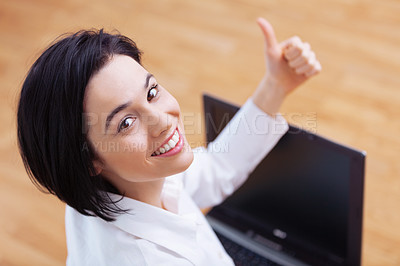 Buy stock photo High angle portrait of an attractive young woman showing thumbs up while using her laptop