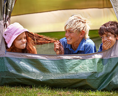 Buy stock photo Kids, camp and outdoors for tent, friends and nature on summer vacation with boys pulling person hair. Children, annoyed girl and holiday for adventure, tease and camping in backyard and on grass
