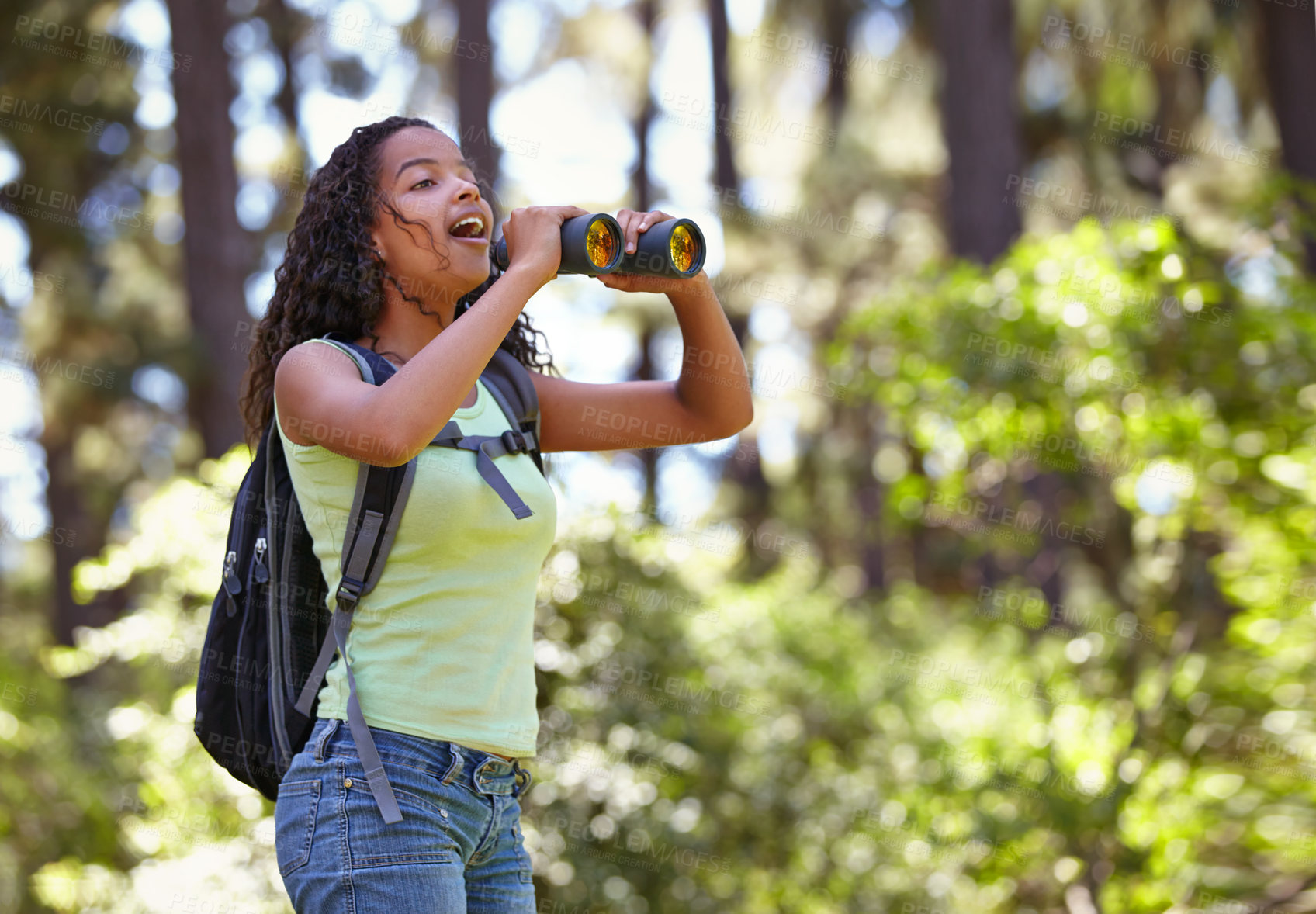 Buy stock photo Happy girl, binoculars and nature with backpack for sightseeing, explore or outdoor vision. Young female person, child or teenager enjoying sight, adventure or bird watching and search in forest