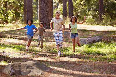 Buy stock photo Nature, adventure and group of kids in forest playing, running and exploring together. Bonding, field and young children for discovery in outdoor woods in summer on vacation, holiday or weekend trip.