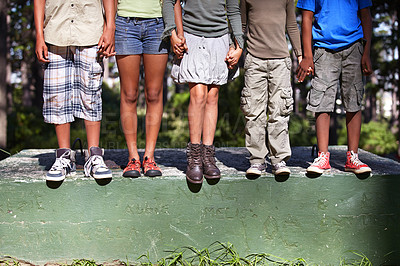 Buy stock photo Cropped shot of four kids standing on a cement block outdoors