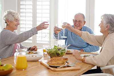 Buy stock photo Wine, cheers and senior friends at lunch in home with smile, celebration and bonding in retirement. Food, drinks and toast with glass, old man and women at dinner table together for happy brunch.