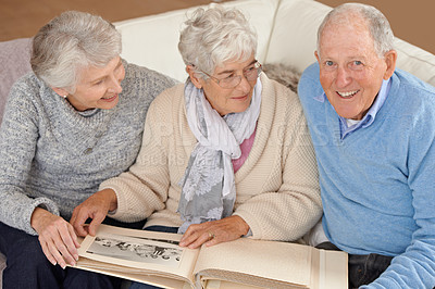 Buy stock photo Old people, friends and photo album for memory nostalgia in retirement on sofa together, photograph or connection. Elderly man, women and picture book in home in Canada for bonding, remember or love
