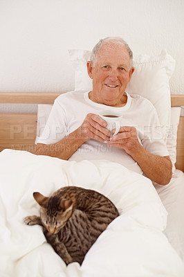 Buy stock photo Senior man, coffee and portrait in bed, smile and relaxing in retirement at home. Elderly male person, bedroom and happy in apartment, cat and hot beverage for peace or calming drink on weekend
