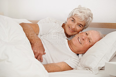 Buy stock photo Senior couple, portrait and relaxing in bed, smiling and love in retirement for bonding on weekend. Elderly people, bedroom and resting or happy in marriage, romance and morning routine at home