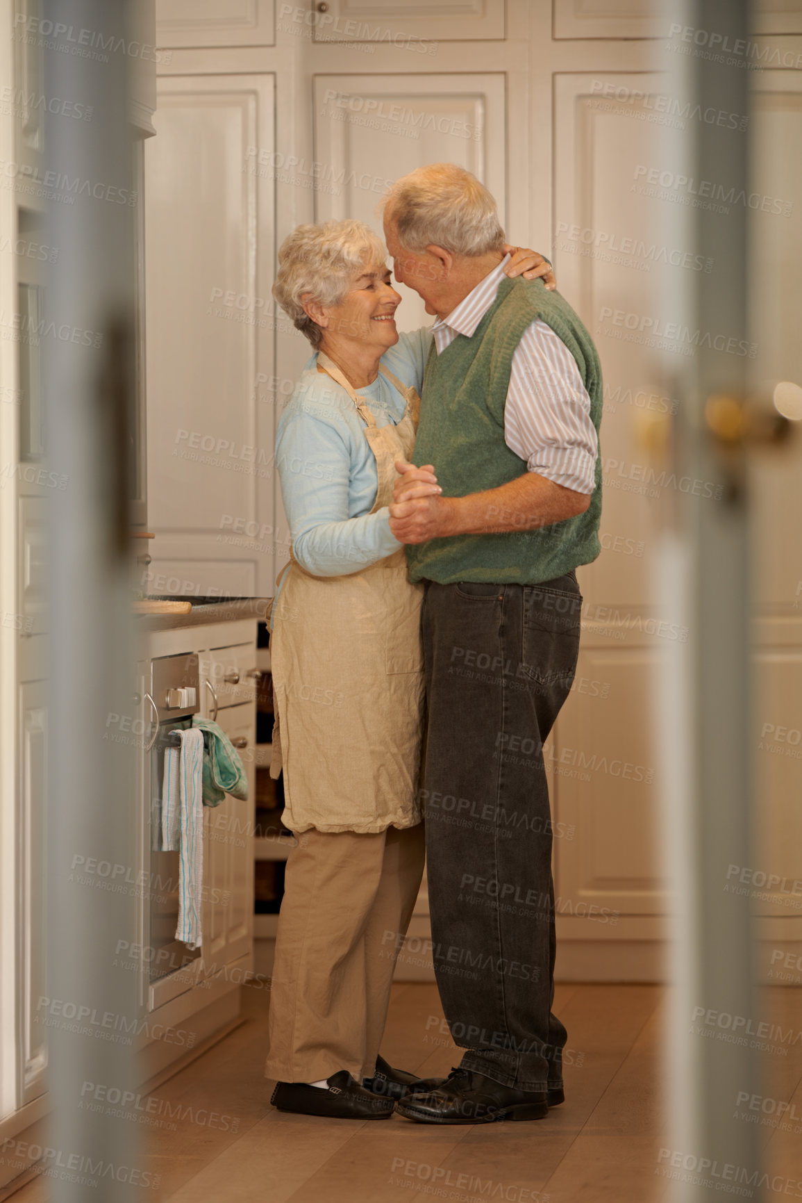 Buy stock photo Elderly, couple and happy with dancing in kitchen for bonding, support and holding hands with romance. Senior, man and woman with hug, embrace and smile for relationship, dancer and love in home 