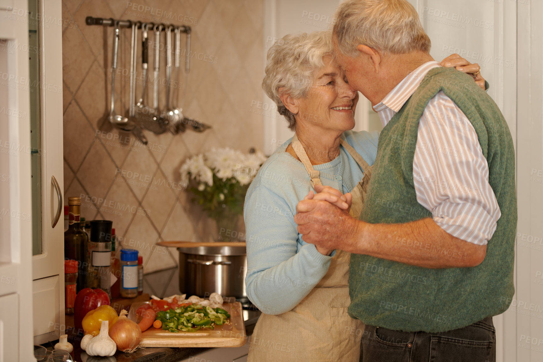 Buy stock photo Senior, couple and smile with dancing in kitchen for bonding, support and holding hands while cooking. Elderly, man and woman with hug, embrace or happiness for relationship, dancer and love in home 