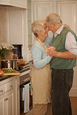 Buy stock photo Senior, couple and happy with dancing in kitchen for bonding, support and holding hands while cooking. Elderly, man and woman with hug, embrace and smile for relationship, dancer and love in home 