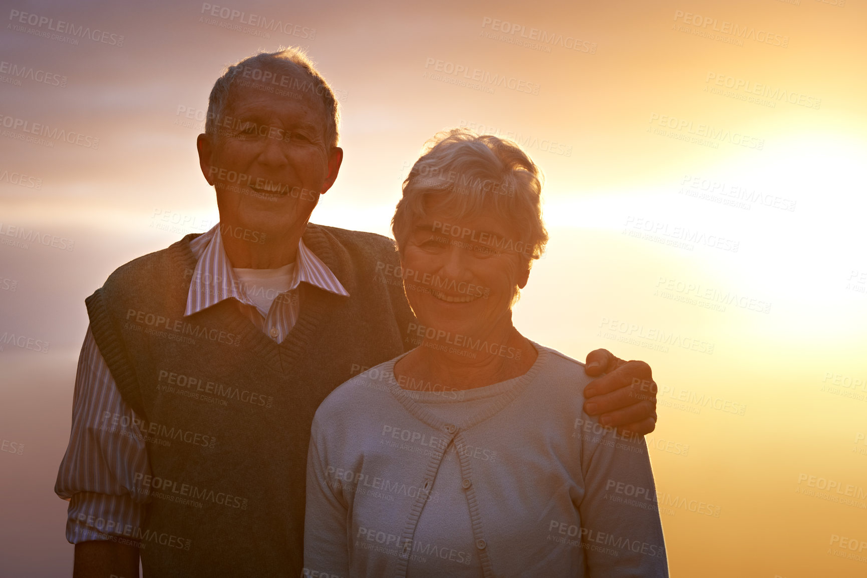 Buy stock photo Portrait, smile and senior couple at sunset for love, romance or retirement bonding outdoor together. Face, autumn or evening with happy elderly man and woman hugging for anniversary or commitment