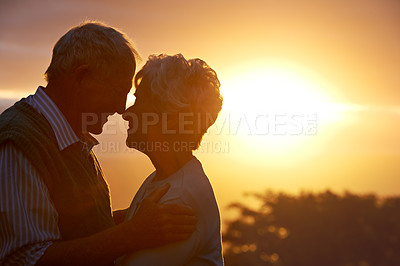Buy stock photo Sunset, senior couple and embrace in nature, care and bonding for connection together outdoor. Man, woman and nose touch for love, romance and support for commitment to relationship in retirement