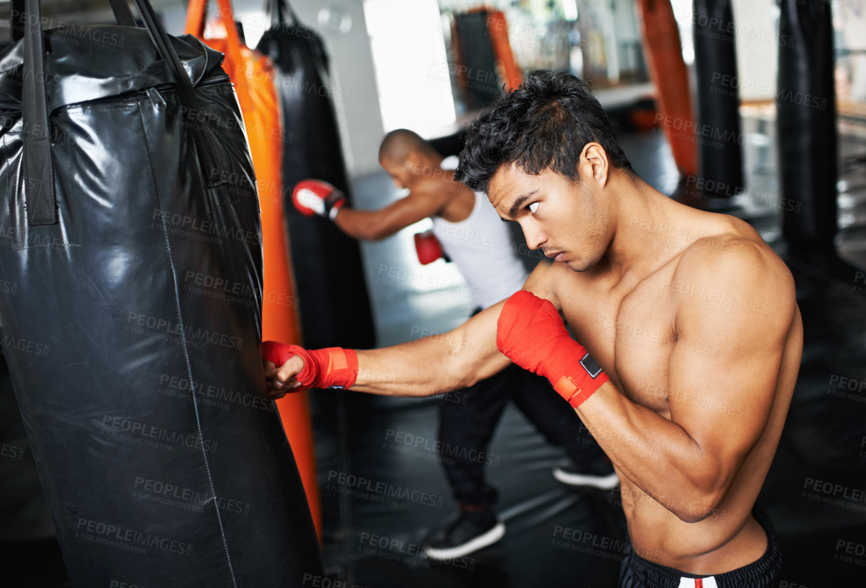 Buy stock photo Punching bag, man and fitness with boxing gloves at a gym for training, resilience or performance. Sports, body and male boxer profile with punch practice for strength, energy for fighting exercise