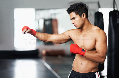Buy stock photo Man, training and gloves in gym for combat match, practice and determined for competition to win. Light weight champion, workout and focus for tough sport, fitness and exercise with endurance for mma