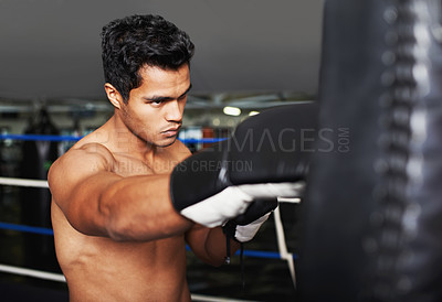 Buy stock photo Sports, serious and man boxer in gym for exercise, workout and combat training for competition. Cardio, health and shirtless male athlete fighter in boxing ring with gloves in fitness center.