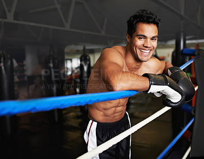 Buy stock photo Portrait of a young man leaning on the ropes of a boxing ring