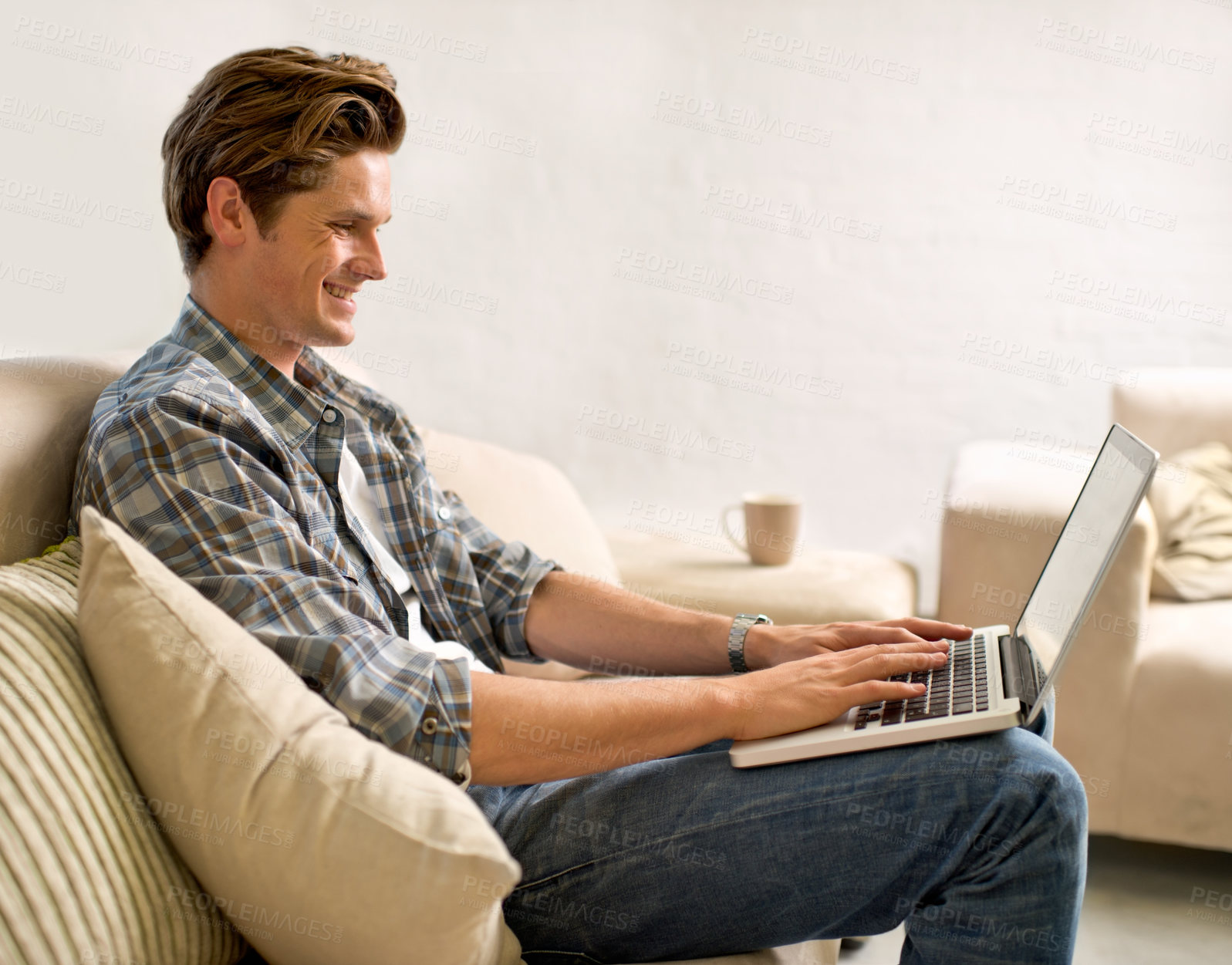 Buy stock photo Laptop, relax and man on sofa in home for watching videos, online networking and website research. Happy, smile and person with computer for internet, remote work and typing email in living room