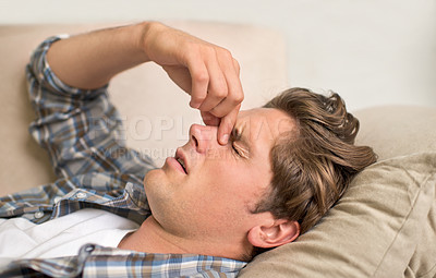 Buy stock photo Man, nose and headache pain on sofa or sinus problem with fatigue or allergy infection, sick or bacteria. Male person, unhappy and tired migraine in London home or flu disease or stress, bug or dizzy