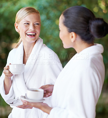 Buy stock photo Two young women having coffee in their bathrobes at the spa