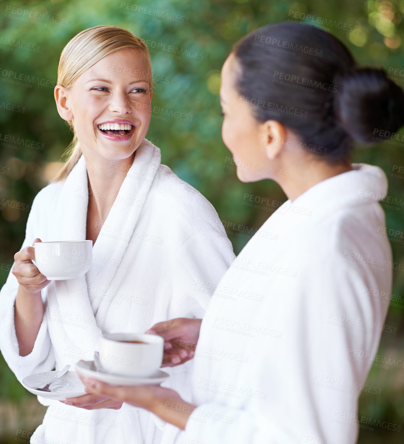 Buy stock photo Two young women having coffee in their bathrobes at the spa