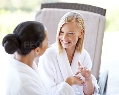Buy stock photo Happy, talking and friends with cream at a spa for hands, treatment and wellness of skin. Smile, skincare and women speaking while applying lotion for moisture, smooth and soft hand at a salon