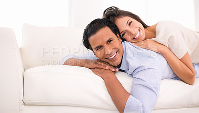 Buy stock photo Portrait of a married couple lying down together on a couch