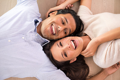 Buy stock photo Top view, couple and laughing on floor in living room, relaxing and bonding together in romantic relationship. Above, man and woman laying on ground with happy, marriage and playful people at home.