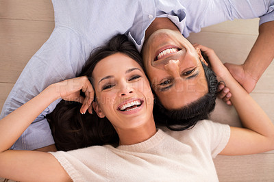 Buy stock photo Portrait, smile and top view of couple holding hands on floor to relax together in home. Above, man and face of happy woman bonding for connection, love or support for healthy relationship in house