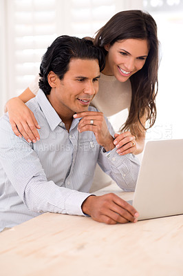 Buy stock photo A husband and wife looking at something on a laptop screen