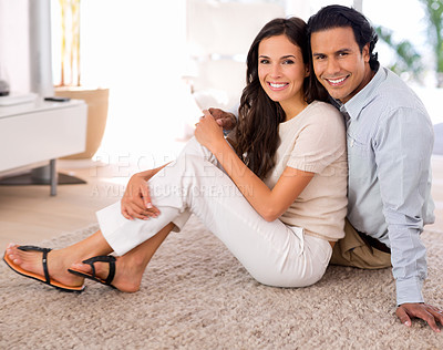 Buy stock photo Happy, love and couple on carpet in living room at home with comfortable romance and care. Smile, marriage and portrait of young man and woman relaxing on floor mat together in lounge at house.