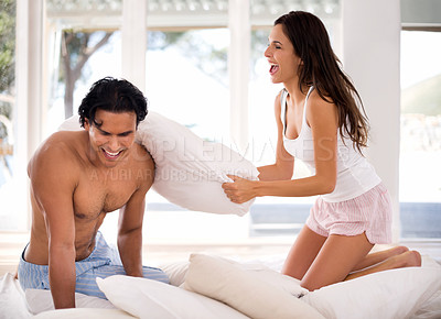 Buy stock photo Pillow, fight and couple on bed with happy battle in home together playing a game in morning. Silly, challenge and people with energy in bedroom and love in marriage with fun bonding in relationship