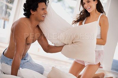 Buy stock photo Pillow, fight and couple on bed with happy battle in home together playing a game in morning. Silly, challenge and people with energy in bedroom and love in marriage with fun bonding in relationship