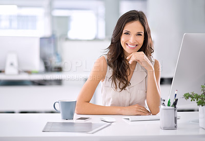 Buy stock photo Shot of an attractive businesswoman sitting at her desk in an office